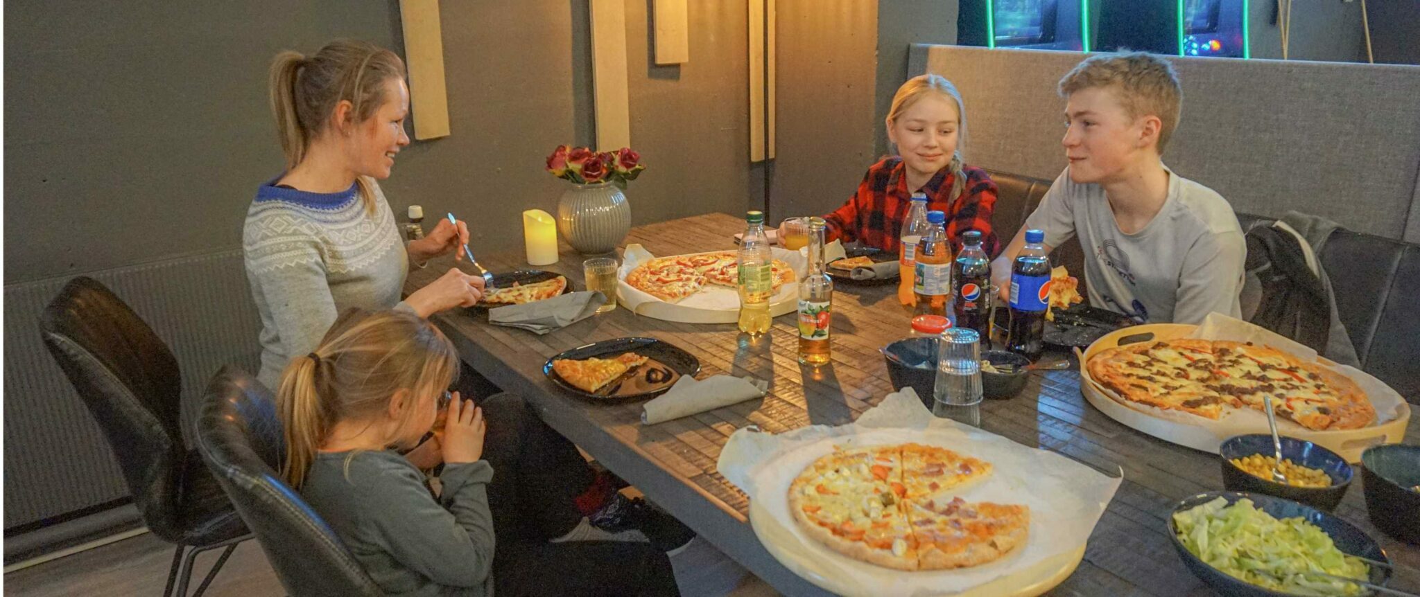 Pizza på treplate-bord — fem personar deler eit måltid medan dei bowlar